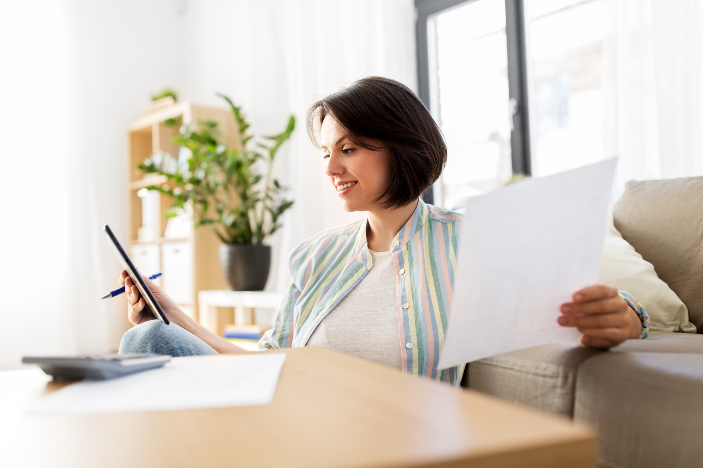 Woman with Tablet Pc, Bills and Calculator at Home