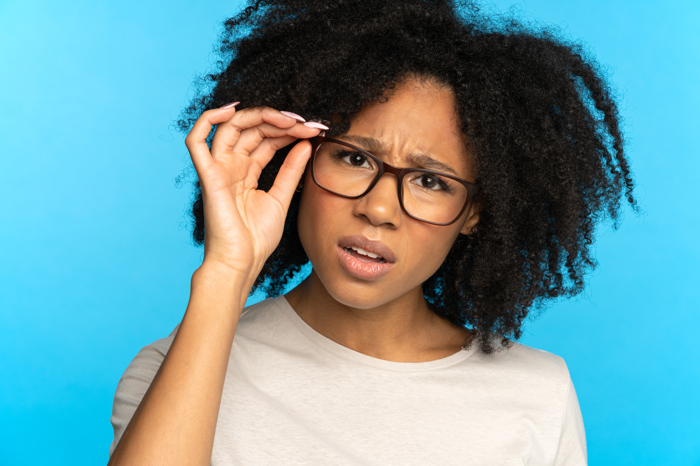 Doubtful Woman Adjusting Eyeglasses